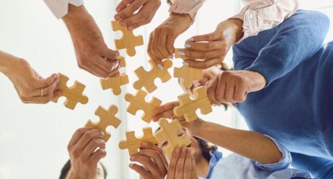 people holding puzzle pieces people holding puzzle pieces